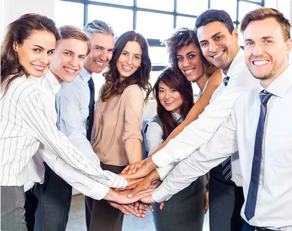 Equipo de trabajo sonriendo con las manos unidas