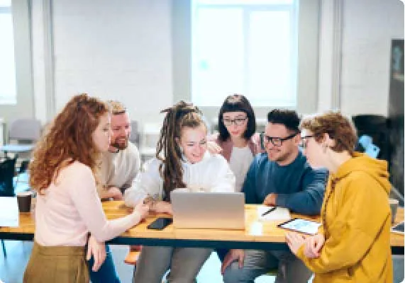 Equipo de trabajo reunido alrededor de un portátil